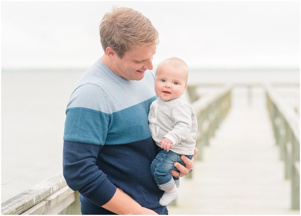 baby boy with dad on the deck at the ocean