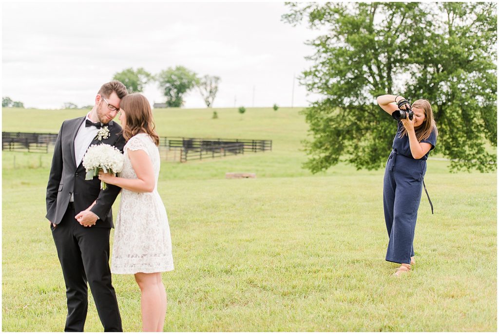 bride and groom with photographer in a field at edgewood barn in Charlottesville